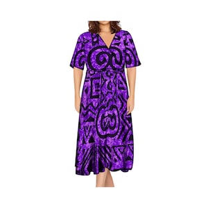 Pode incluir: Um vestido roxo de amarrar com um padrão geométrico. O vestido tem mangas curtas e um decote em V.