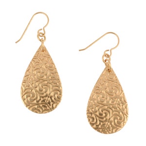 May include: Gold teardrop earrings with a detailed filigree pattern.