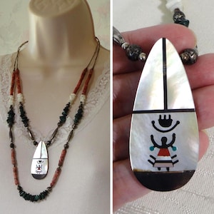 May include: A multi-strand necklace featuring a teardrop-shaped pendant made of iridescent mother-of-pearl inlaid with a black, red, and turquoise figure. The necklace includes segments of orange coral, white shell, and dark green stone beads.