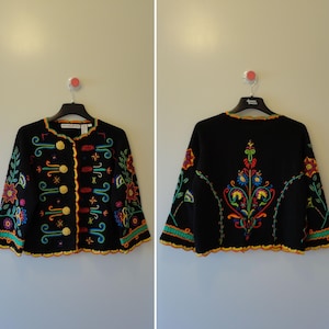 May include: Black embroidered jacket with colorful floral and scrollwork designs. The jacket features gold buttons and a scalloped hem. The back of the jacket has a large embroidered floral design.