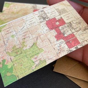 May include: A vintage map of Palm Springs, California, showing the city's layout and surrounding areas. The map is printed on a cream-colored paper with red and brown lines and text.