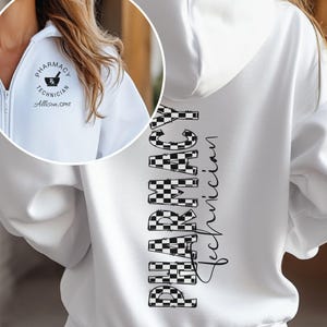 May include: White zip-up hoodie with a hood. The back of the hoodie features the words "PHARMACY Technician" in a checkered pattern. The front has a small circular logo with the words "PHARMACY TECHNICIAN" and the name "Allison, CPhT".
