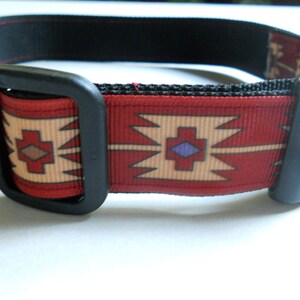 May include: A red, beige, and purple patterned dog collar with a black plastic buckle.