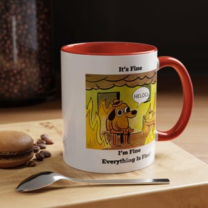 May include: White ceramic mug with a red interior and handle. The mug features a cartoon dog in a burning room with the text "It's Fine" and "I'm Fine Everything Is Fine!"