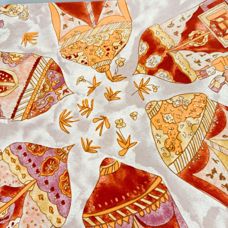 May include: A square fabric scarf featuring a repeating pattern of stylized, pointed umbrella-like shapes in shades of orange, red, and purple. The design includes intricate floral and geometric details on a light gray background with small orange floral motifs.