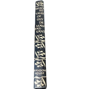 May include: A dark blue book spine with the title "Selected Tales of Guy de Maupassant" in white. The spine has a repeating white floral pattern and the publisher's name, "Random House."