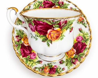 May include: A white porcelain teacup and saucer set featuring a vibrant floral pattern of deep red and yellow roses with green leaves. The rim of both the cup and the saucer is scalloped and finished with a delicate gold trim, including a gold handle.