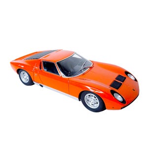 Puede incluir: Un coche deportivo de color naranja brillante con un diseño aerodinámico. El coche tiene rejillas negras, ruedas plateadas y un techo negro. Es un modelo clásico, probablemente de colección.