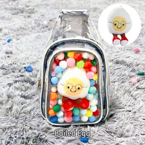 Puede incluir: Una mochila transparente con cierre de cremallera, llena de pompones de colores y un personaje de huevo cocido de peluche con gafas. La mochila tiene un peque&ntilde;o personaje de huevo de peluche adjunto.