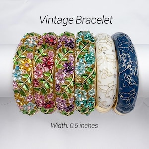 May include: Six vintage bracelets with floral designs. The bracelets are in various colors, including gold, green, pink, purple, white, and blue. Each bracelet is approximately 0.6 inches wide.