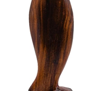 May include: A wooden sculpture of a bird with a long neck and a rounded body. The sculpture is made of dark brown wood with visible grain. The bird is perched on a square base.