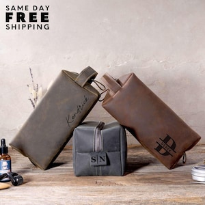May include: Three leather toiletry bags in gray and brown tones. One rectangular bag is gray with a zipper, and the other two are rectangular with handles. The text "Kendrick" and "Derek" are visible on the bags. The text "SAME DAY FREE SHIPPING" is at the top.