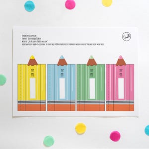 May include: A white card featuring four colorful pencil-shaped designs. Each pencil is a different color: yellow, blue, green, and pink. The pencils have brown tips and the text "DU BIST". Colorful confetti dots the background.