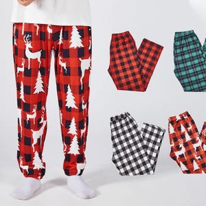 Puede incluir: Pantalones de pijama a cuadros rojos y negros con diseños de ciervos y árboles de Navidad blancos. También se muestran pantalones de pijama adicionales en cuadros rojos y negros, cuadros verdes y negros, cuadros blancos y negros y diseños de ciervos rojos.