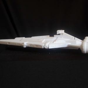 May include: A white plastic model of a spaceship with a long, narrow body and a large engine at the back.