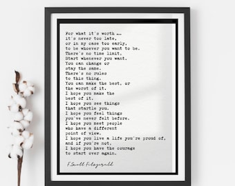 May include: Black framed print featuring a quote by F. Scott Fitzgerald in a typewriter font. The quote begins "For what it's worth..." and continues with inspirational text. A sprig of cotton stems is visible on the left.