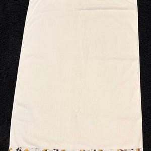 K&ouml;nnte beinhalten: Eine wei&szlig;e Keramik-Tasse mit schwarzem Henkel und dem Text "But First, Coffee" in schwarzer, fetter Schrift. Die Tasse steht auf einer wei&szlig;en Oberfl&auml;che.