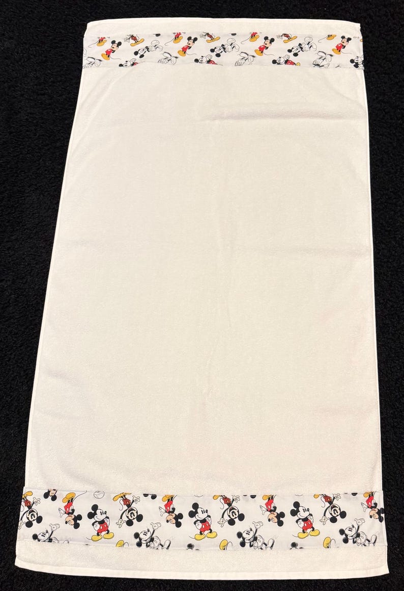 K&ouml;nnte beinhalten: Eine wei&szlig;e Keramik-Tasse mit schwarzem Henkel und dem Text "But First, Coffee" in schwarzer, fetter Schrift. Die Tasse steht auf einer wei&szlig;en Oberfl&auml;che.