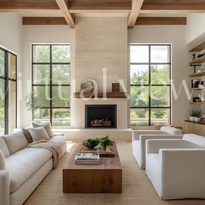 May include: A modern living room with a white sectional sofa, two white armchairs, a wooden coffee table, and a fireplace with a black mantel. The room has large windows with black frames and a view of trees and a pool. The walls are white and the floor is a light wood.