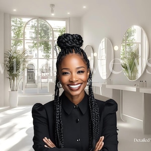 May include: A woman with long black braids smiles at the camera. She is wearing a black collared shirt and has her arms crossed. The background is a white room with large windows and mirrors.
