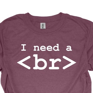 May include: Heather maroon t-shirt with the text "I need a <br>" printed in white.