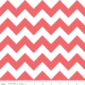 Pode incluir: Um tecido com um padrão de chevron branco e coral. O tecido é mostrado com uma régua em polegadas.