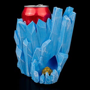 May include: A blue crystal-shaped drink holder with a red can inside and a yellow and black dice in the bottom.