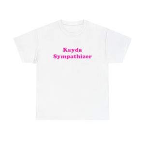 May include: A white short-sleeved t-shirt featuring the text Kayda Sympathizer printed in a bold, bright pink font across the centre of the chest. The garment has a classic crew neckline and a standard fit, showcasing a clean and simple design.