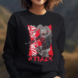 May include: Black sweatshirt with a red and white graphic of a female character with a mask holding a sword. The text 'ATTACK' is written in red below the graphic.