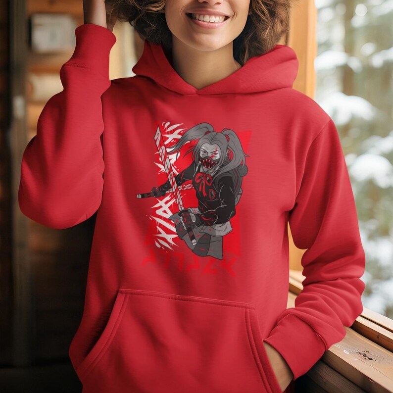 May include: A red hoodie with a graphic print of a female anime character with a mask and pigtails holding a sword. The character is standing in front of a white background with black kanji characters.