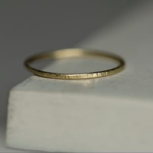 Puede incluir: Un fino anillo de banda de oro con textura martillada.