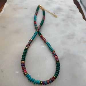 Beaded necklace made with red and blue turquoise colored beads,malachite .Necklaces have gold plated findings, Lobster clasp and oval charm.