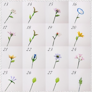 May include: A grid of 16 images of glass flowers and stems. The flowers are in various colors, including white, pink, yellow, blue, and purple. Each flower has a green stem and leaf. Numbers 13-28 are in the corners of each image.