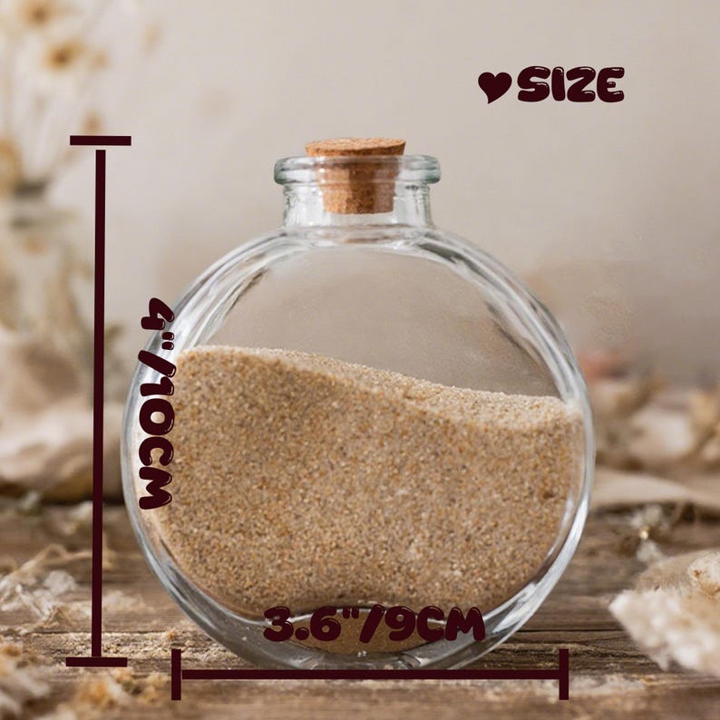 May include: A clear, round glass bottle with a cork stopper, partially filled with beige sand. The text "SIZE" appears at the top right. Measurement lines indicate a height of 4 inches and a width of 3.6 inches for the glass container.