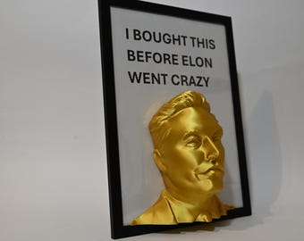 May include: A framed gold-colored bust of Elon Musk with the text "I bought this before Elon went crazy" printed on the white background.