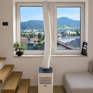 May include: A white portable air conditioner with a black top panel and the brand name elit printed on the front. A flexible white exhaust hose extends from the top of the unit to the window frame. The unit features horizontal air vents.