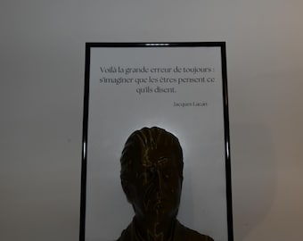 May include: A framed black and white print with a quote by Jacques Lacan: "Voilà la grande erreur de toujours: s'imaginer que les êtres pensent ce qu'ils disent."