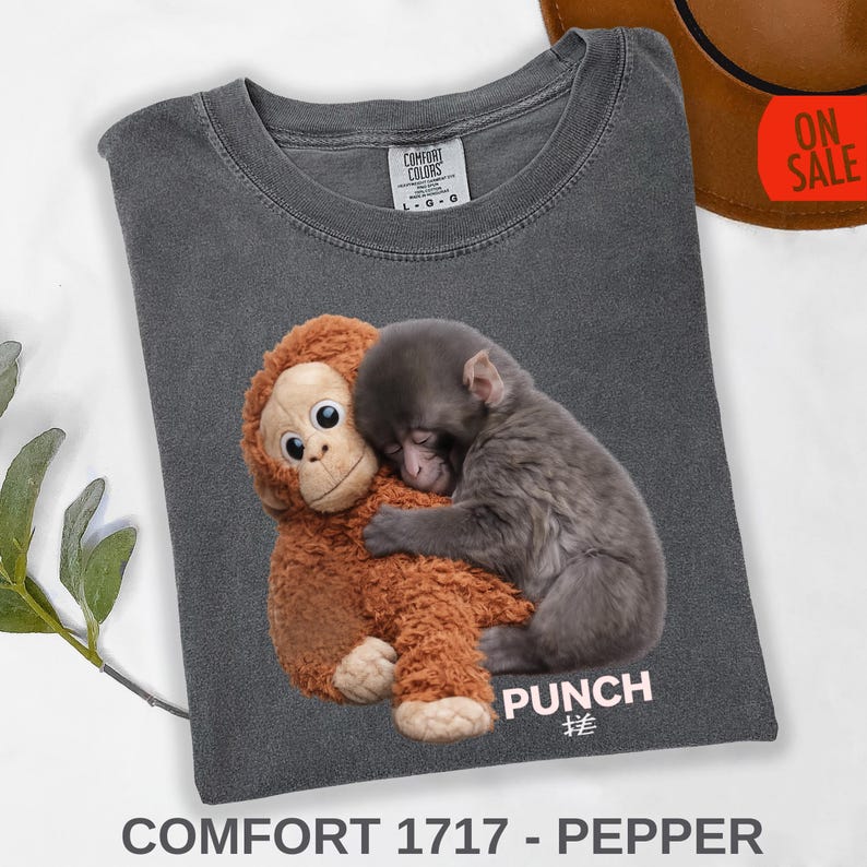 Cute baby monkey punch shirt design with realistic macaque cuddling stuffed animal