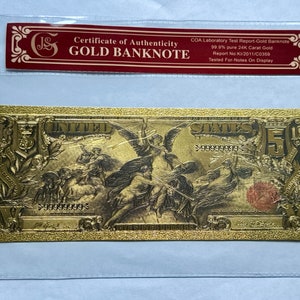 May include: A gold-plated $5 US banknote with a certificate of authenticity. The banknote features a design of a winged figure holding a sword and shield. The certificate states that the banknote is 99.9% pure 24K carat gold.