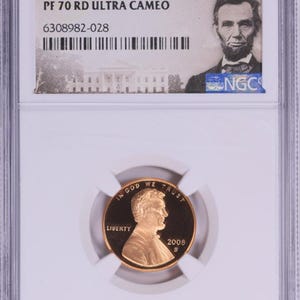 May include: A 2008 S 1C penny graded PF 70 RD ULTRA CAMEO, encapsulated in a protective holder. The coin features Abraham Lincoln's profile and the text "IN GOD WE TRUST" and "LIBERTY". The holder includes the NGC logo and serial number.