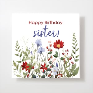 May include: A white card with the text "Happy Birthday sister!" in red and purple lettering. The card is decorated with a border of colorful flowers and greenery.