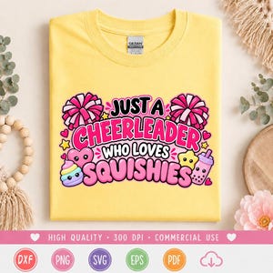 May include: A bright yellow t-shirt featuring a colorful graphic with the text "JUST A CHEERLEADER WHO LOVES SQUISHIES". The design includes pink pom-poms, a smiling heart, a star, and a boba tea cup, all rendered in a playful, cartoon style.