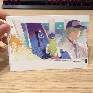 May include: A white rectangular card with anime-style illustrations of characters in a fantasy setting. The card includes text that reads, "Make your wonderful dream a reality, and it will become your truth. If anyone can, it's you!"