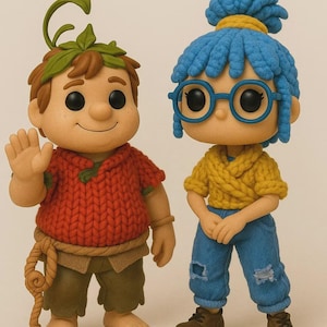 Op de afbeelding: Twee grillige beeldjes, een jongen en een meisje, staan naast elkaar. De jongen draagt een rode gebreide trui, een bruine broek en een bladhoofddeksel. Het meisje heeft blauw haar, een bril, een gele gebreide top en een blauwe jeans. Beide dragen schoenen.