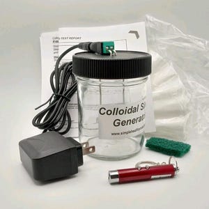 May include: A colloidal silver generator kit with a glass jar, black lid, power adapter, and red laser pointer. The jar has a label that reads "Colloidal Silver Generator". Includes a green scrub pad and a test report.