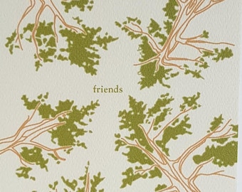 May include: A greeting card with a white background and a green and orange illustration of tree branches. The text "friends" is printed in orange on the card.