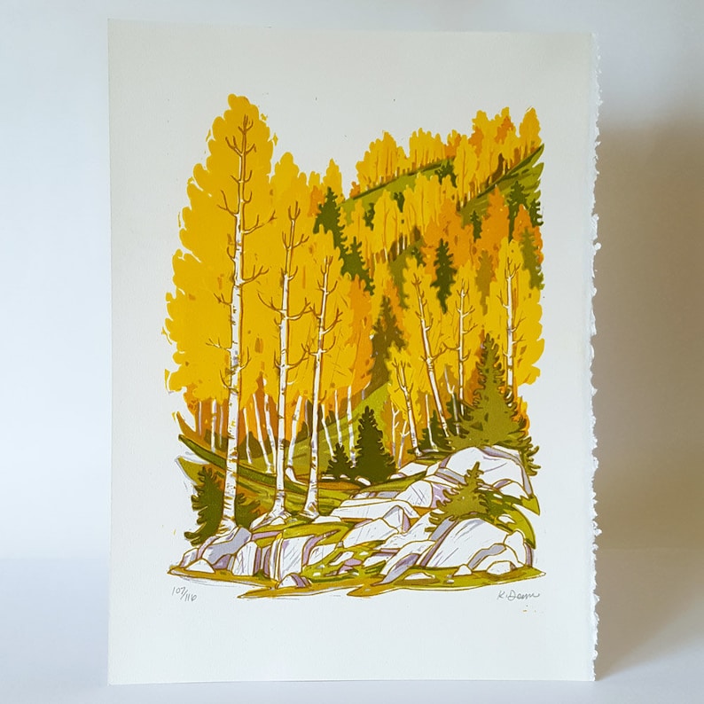 May include: A print of a landscape featuring a forest scene with yellow and green trees, white birch trees, and large gray rocks. The print is numbered 153/160 and signed by the artist. The artwork has a textured, hand-made appearance.