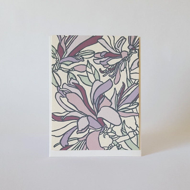 May include: A card with a floral design featuring purple and pink flowers with a cream background.
