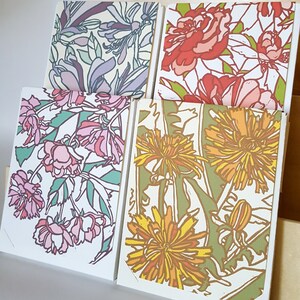 May include: Four cards with floral designs. The cards feature different flowers, including pink, red, yellow, and green flowers. The cards are all white with a white border.