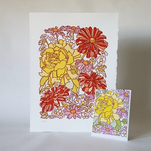 May include: A colorful floral print with red, yellow, and pink flowers. The print features a variety of flowers, including roses, daisies, and peonies. The flowers are arranged in a loose, organic pattern.